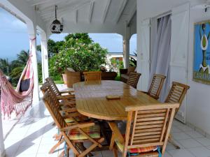 a wooden table and chairs on a patio at Horizon Karukera in Sainte-Rose