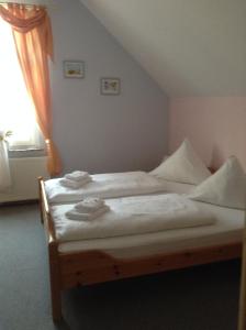 - une chambre avec un lit doté de draps blancs et une fenêtre dans l'établissement Hotel Mühleneck, à Hage