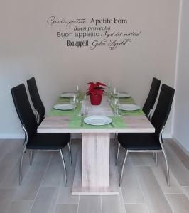 a dining room table with chairs and a table with a vase at Villa Wally in Merano