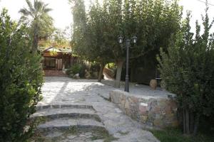 a stone walkway with a street light and trees at Akti Damnoni in Damnoni