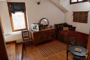 a bedroom with a bed and a table and a mirror at Castle Cottage Bed & Breakfast in Belogradchik