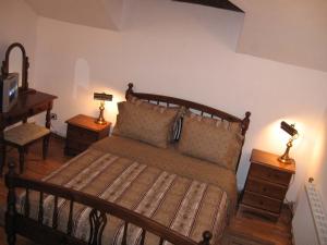 a bedroom with a wooden bed with two night stands at Castle Cottage Bed & Breakfast in Belogradchik