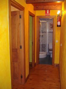 a hallway leading to a bathroom with a toilet at Casa El Carrelu in Po