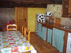 a kitchen with a table and a refrigerator at Casa El Carrelu in Po
