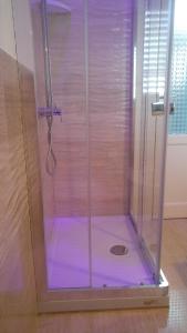 a shower with a glass door in a bathroom at Bet Home in Palermo