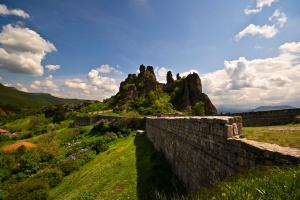 a stone wall with a mountain in the background at Castle Cottage Bed & Breakfast in Belogradchik