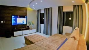 una camera da letto con un letto grande e una TV a schermo piatto di Marina's Praia Itaipu a Niterói