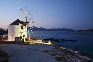 a windmill sitting on the side of a body of water at Windmill Villa in Koufonisia