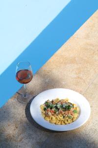 a plate of food next to a glass of wine at Xenon Estate in Spetses