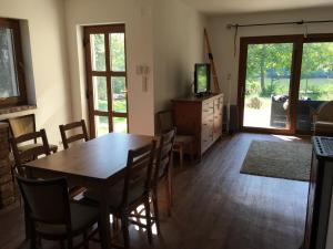 a dining room with a table and chairs and a television at Kemencés Házikó in Szarvas