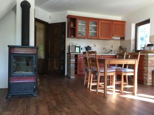 uma cozinha com um fogão a lenha, uma mesa e cadeiras em Kemencés Házikó em Szarvas