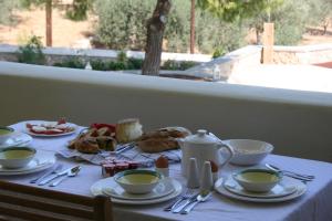 a table with cups and plates of food on it at Xenon Estate in Spetses