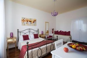 um quarto com uma cama e uma mesa com uma tigela de fruta em Il Portico Camere e Caffè - centro Città em Savignano sul Rubicone