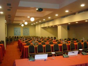 een kamer vol tafels en stoelen met rode tafellakens bij Limira Mare Hotel in Neapolis