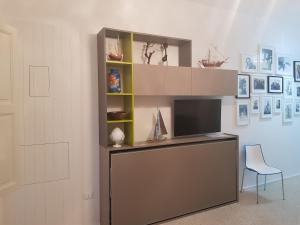 a entertainment center with a tv and a chair in a room at casa azzurra in San Foca
