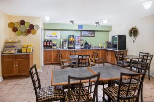 un restaurante con mesa, sillas y barra en Days Inn by Wyndham Abbeville, en Abbeville