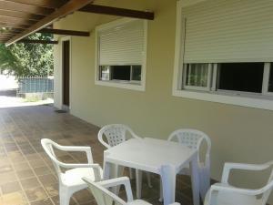 una mesa blanca y sillas en un patio en Monsal Casa para Temporada, en Florianópolis