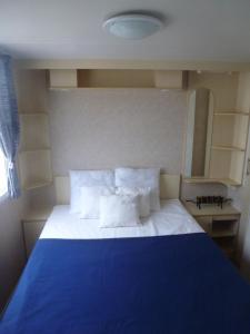 シジャンにあるMobil-Home a Sigeanのベッドルーム(白い枕の青いベッド1台付)