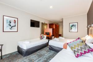 
a hotel room with two beds and a television at Tonsley Hotel in Adelaide
