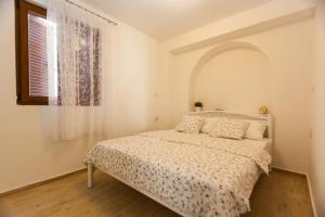 a white bedroom with a bed and a window at Deluxe Villa Nina in Novi Vinodolski