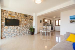 a living room with a stone wall and a tv at Deluxe Villa Nina in Novi Vinodolski