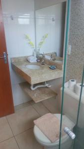 uma casa de banho com um lavatório e um WC em Pousada Manna em Olímpia