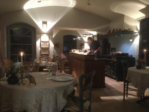 Un homme debout dans la cuisine d'un restaurant avec des tables dans l'établissement Les Rosées, à Mougins