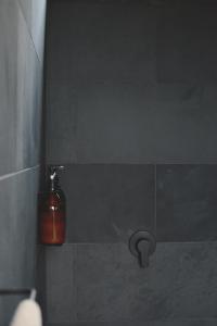 a bathroom with a soap dispenser on a wall at The Huts in Ahipara