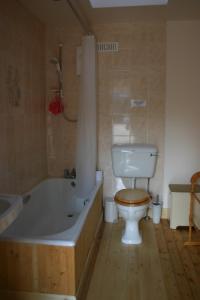 Das Bad ist mit einem WC, einer Badewanne und einer Badewanne ausgestattet. in der Unterkunft Woodcroft Cottage in Ayr