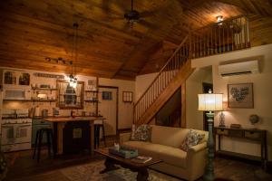 a living room with a couch and a kitchen at Heaven's Hideaway- perfect getaway near the river! in Luray