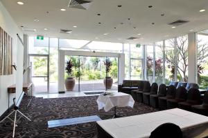 sala de estar con sofás, mesa y ventanas en Absolute Beachfront Opal Cove Resort, en Coffs Harbour