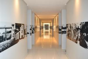 a hallway of a building with black and white photographs on the walls at Dunen Hotel in Piranhas