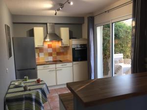 a kitchen with a refrigerator and a table and a window at La maison de Virginie 6 a 12 personnes -300 m de la plage- vélos a disposition in Saint Cyprien Plage
