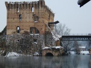 a castle in the middle of a river with a bridge at Il Borghetto Vacanze nei Mulini in Valeggio sul Mincio
