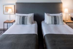 two beds sitting next to each other in a hotel room at KOS Pilar Hotel in Pilar