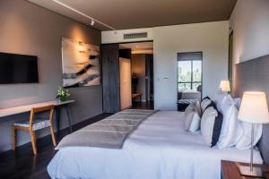a hotel room with a large bed and a desk at KOS Pilar Hotel in Pilar
