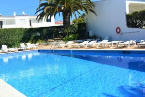 a large swimming pool with chairs and a house at Casa Vista Paraíso in Carvoeiro