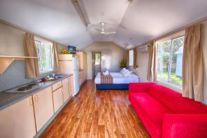 a living room with a red couch and a bed at Ingenia Holidays Middle Rock in One Mile