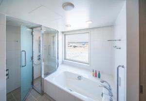 a bathroom with a tub and a shower and a window at Haneda Excel Hotel Tokyu Haneda Airport Terminal 2 in Tokyo
