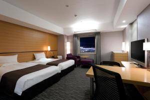 a hotel room with two beds and a desk at Haneda Excel Hotel Tokyu Haneda Airport Terminal 2 in Tokyo