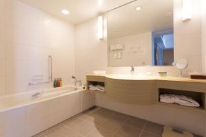 a bathroom with a tub and a sink and a bath tubermott at Haneda Excel Hotel Tokyu Haneda Airport Terminal 2 in Tokyo