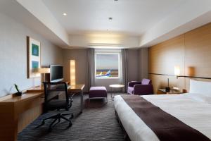 a hotel room with a bed and a desk and a window at Haneda Excel Hotel Tokyu Haneda Airport Terminal 2 in Tokyo