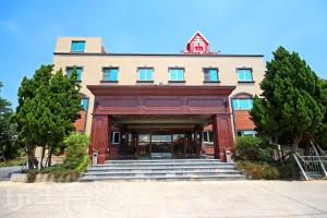 a red building with stairs leading into a building at Ludao Hotel in Jinning