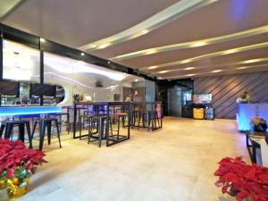 eine Bar mit Hockern und Tischen in einem Zimmer in der Unterkunft Beauty Hotels Taipei - Hotel B6 in Taipeh