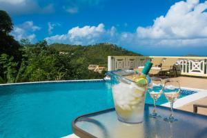 a drink on a table next to a swimming pool at Heavenly Suites in La Feuillet