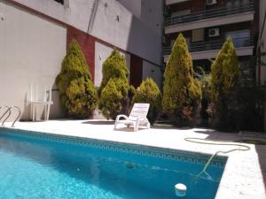 a white chair sitting next to a swimming pool at Luminoso monoambiente en Recoleta in Buenos Aires