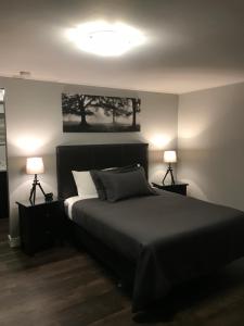 1 dormitorio con 1 cama grande y 2 lámparas en 94 Motel & RV Park en One Hundred Mile House