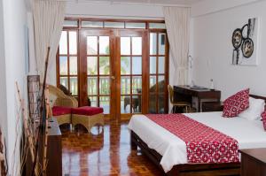 a bedroom with a bed and a desk and a window at Sea Dream Resorts in Dauin