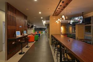 a bar in a restaurant with a long counter at POP! Hotel Banjarmasin in Banjarmasin