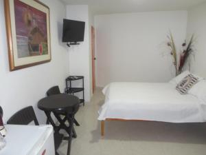 1 dormitorio con cama, mesa y TV en Kings House, en San Andrés